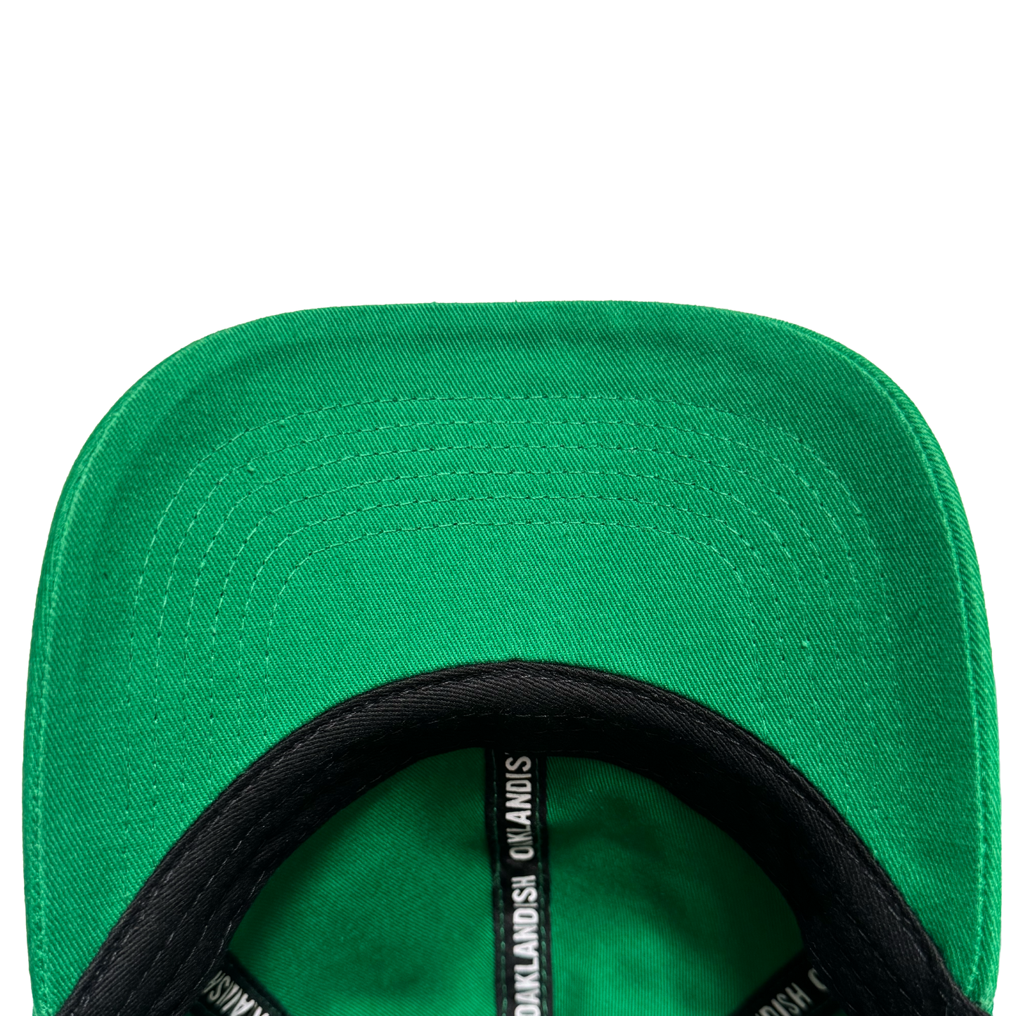 Close-up of the underside of the Oakland Ballers Dad Hat brim, highlighting detailed stitching. The black inner band displays white repeating text: "Oakland Ballers," echoing the brand's iconic style. Set against a plain white background.