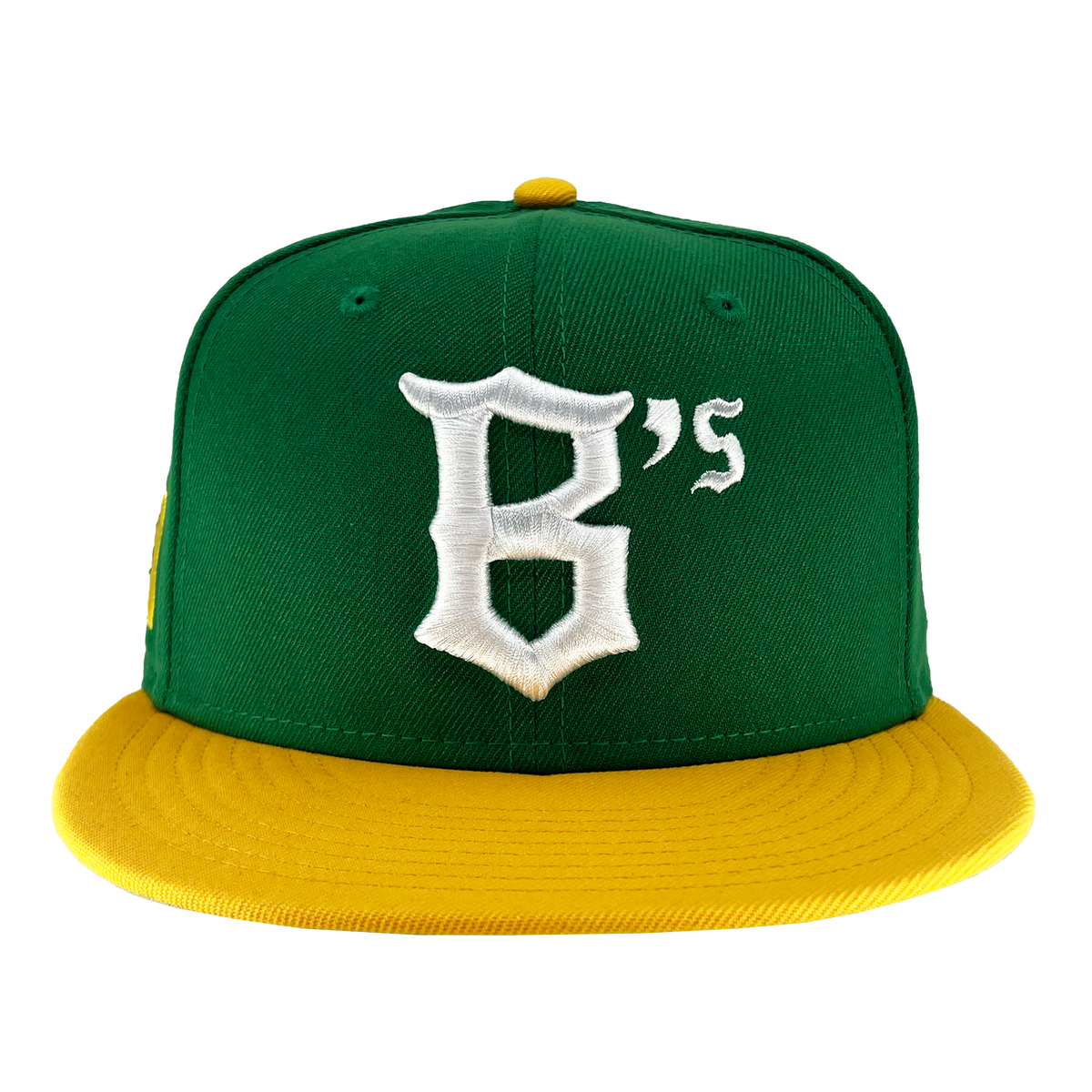 The New Era Oakland Ballers 59Fifty Cap features a green body with a flat yellow brim and a top button that matches in yellow. The front of the cap showcases a white, stylized letter "B" followed by a smaller white "'s," symbolizing the Oakland Ballers. The image background is white.