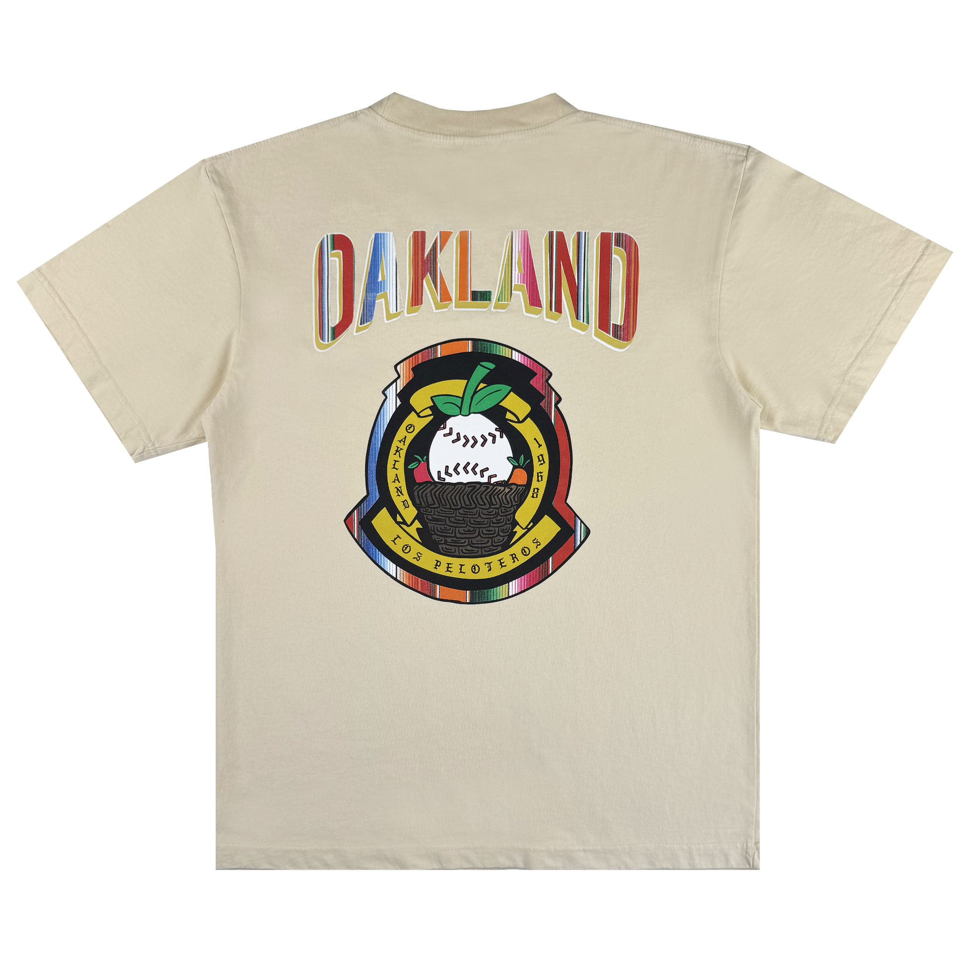 The Oakland Beisbol Tee by Oakland Ballers is a beige shirt featuring "OAKLAND" in bright letters on the back, plus a vibrant emblem with a baseball, green leaves, and "POR LOS PELOTEROS" on yellow and red banners.